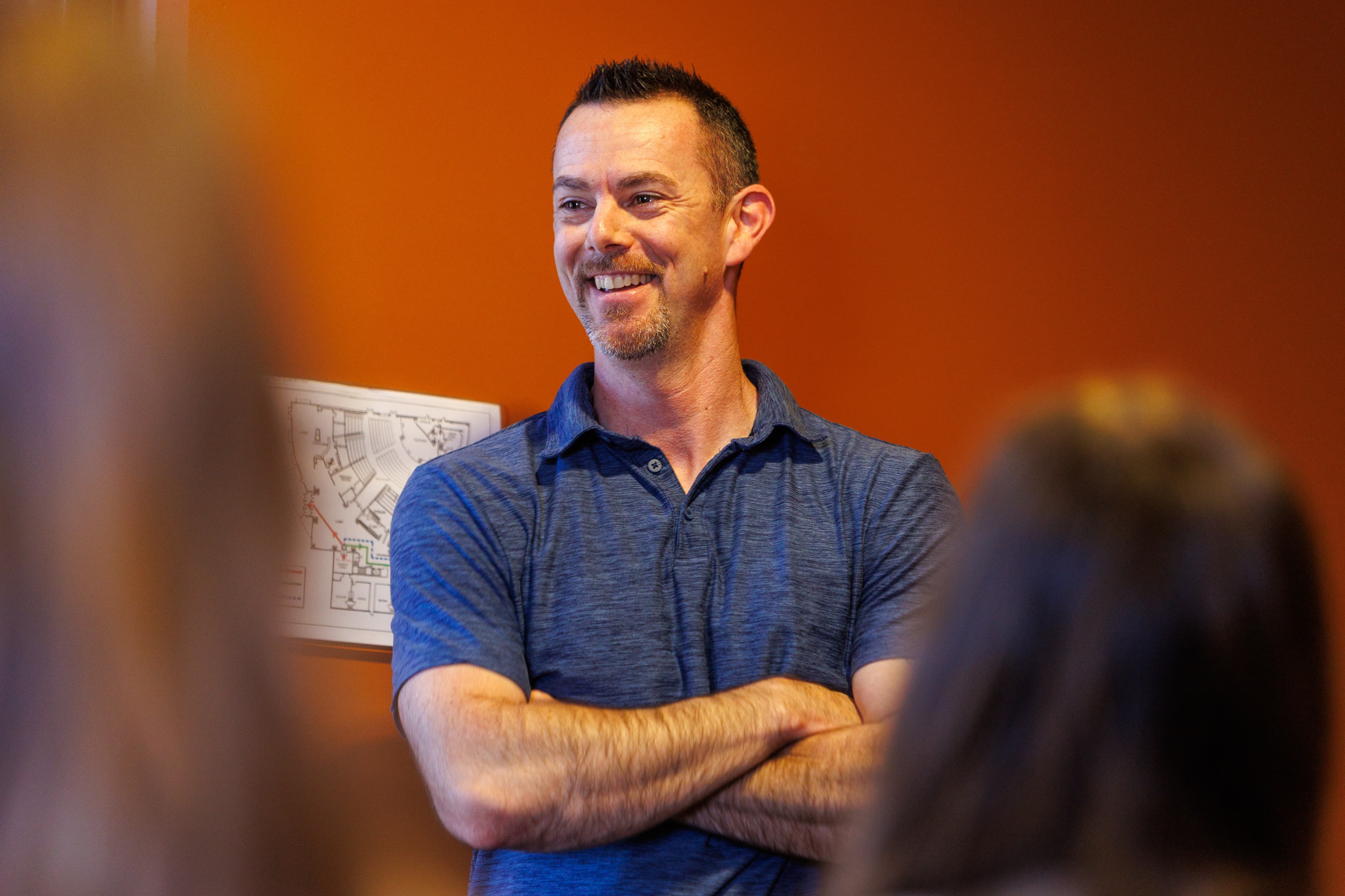 David Forster speaking to a group with arms crossed
